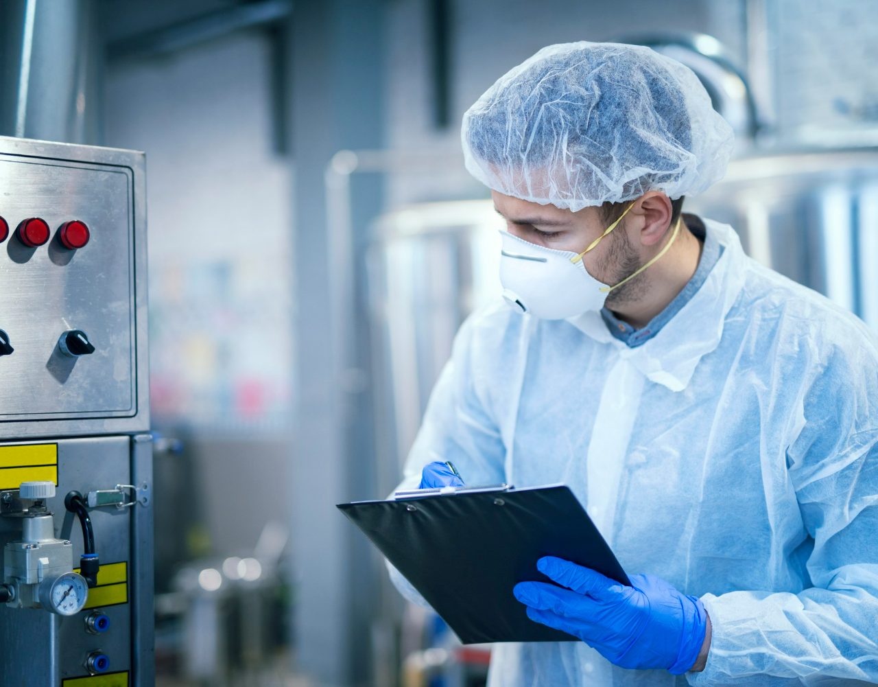 https://www.magemi.it/wp-content/uploads/2022/06/technologist-expert-in-protective-uniform-with-hairnet-and-mask-taking-parameters-from-industrial-machine-in-food-production-plant-1280x1001.jpg
